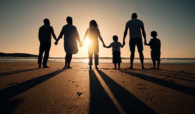 Silhueta de família de mãos dadas na praia​